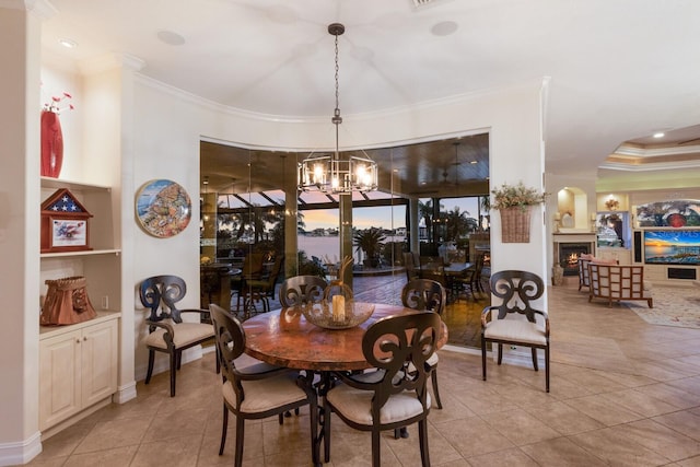 801 3rd St E, Palmetto, FL 34221 - tiled dining room with a chandelier, ornamental molding, a lit fireplace, and built in features