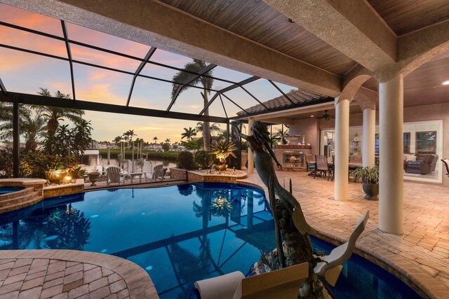 801 3rd St E, Palmetto, FL 34221 - pool at dusk featuring a patio, a ceiling fan, area for grilling, a lanai, and a pool with connected hot tub