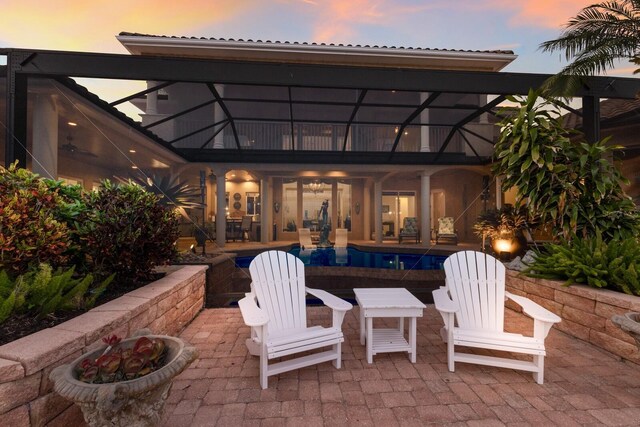 801 3rd St E, Palmetto, FL 34221 - patio terrace at dusk with a patio area, an outdoor pool, and glass enclosure
