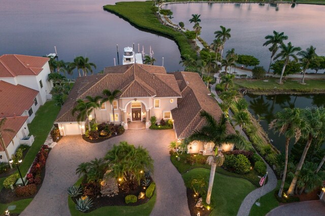801 3rd St E, Palmetto, FL 34221 - view of front of property with curved driveway, a water view, a tiled roof, and stucco siding