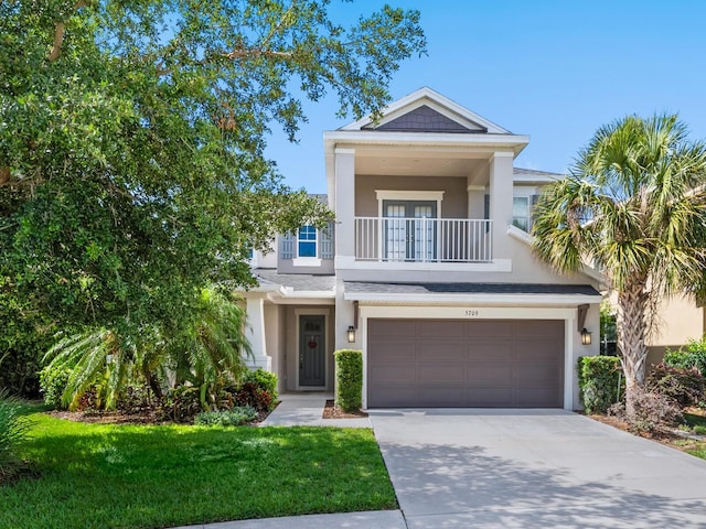 5709 Wild Sage Cir, Sarasota, FL 34238 - view of front of house featuring a balcony, stucco siding, driveway, a garage, and french doors