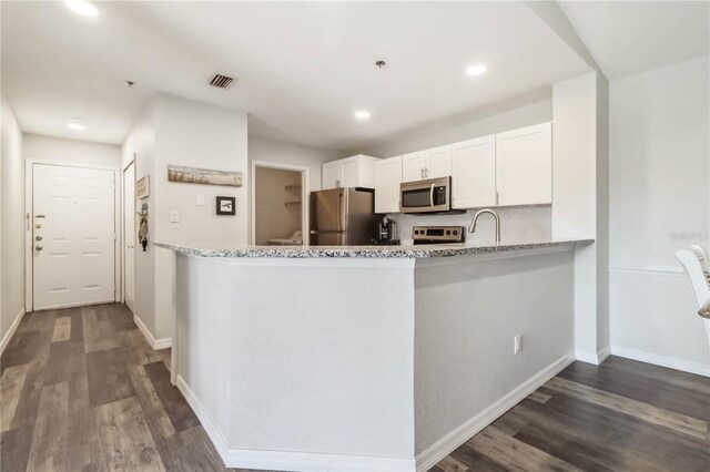 4061 Crockers Lake Blvd Unit 27, Sarasota, FL 34238 - kitchen with stainless steel appliances, dark wood-style flooring, white cabinetry, light stone countertops, and recessed lighting