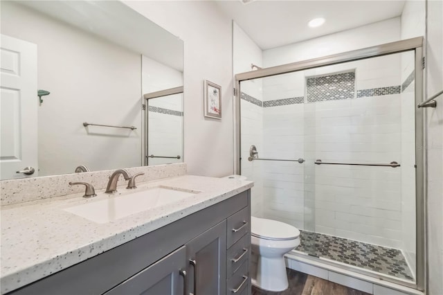 4061 Crockers Lake Blvd Unit 27, Sarasota, FL 34238 - bathroom featuring a stall shower, vanity, toilet, and wood finished floors