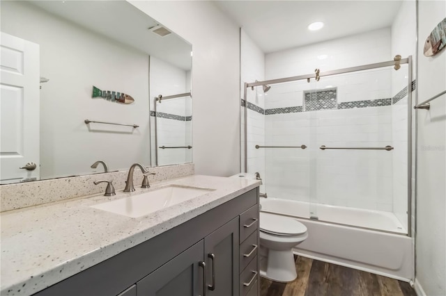 4061 Crockers Lake Blvd Unit 27, Sarasota, FL 34238 - bathroom featuring wood finished floors, vanity, toilet, and combined bath / shower with glass door
