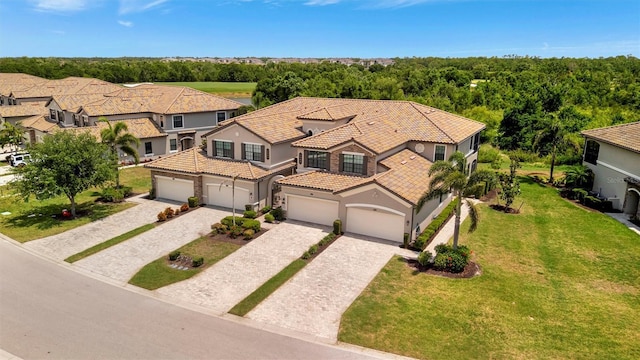 5843 Wake Forest Run Unit 104, Bradenton, FL 34211 - view of front of home featuring stucco siding, decorative driveway, a tiled roof, a front yard, and a residential view