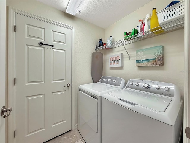 5843 Wake Forest Run Unit 104, Bradenton, FL 34211 - laundry area featuring washer and dryer, light tile patterned flooring, and a textured ceiling