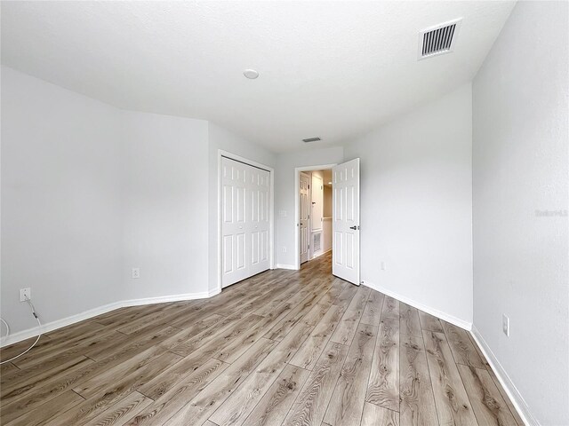 1053 Grantham Dr, Sarasota, FL 34234 - unfurnished bedroom featuring light wood-style floors, baseboards, and a closet