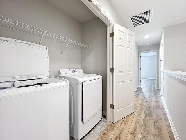 1053 Grantham Dr, Sarasota, FL 34234 - laundry area featuring light wood-style flooring, separate washer and dryer, and baseboards