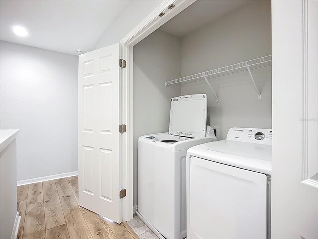 1053 Grantham Dr, Sarasota, FL 34234 - laundry room with separate washer and dryer, light wood-style flooring, and baseboards