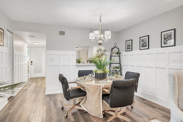 6501 Mourning Dove Dr Unit 215, Bradenton, FL 34210 - dining space featuring a decorative wall, a chandelier, wood finished floors, and wainscoting