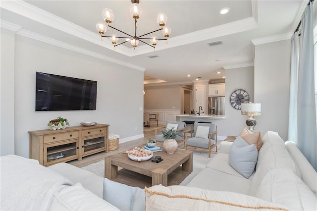 15752 Sacile Ln, Bradenton, FL 34211 - living area with a chandelier, ornamental molding, a raised ceiling, light wood-type flooring, and recessed lighting