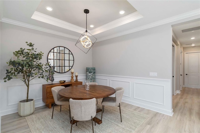 15752 Sacile Ln, Bradenton, FL 34211 - dining area featuring light wood-style floors, a decorative wall, crown molding, wainscoting, and recessed lighting