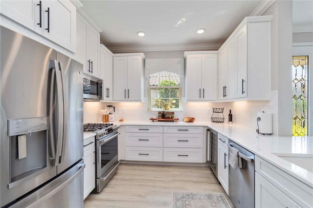 15752 Sacile Ln, Bradenton, FL 34211 - kitchen with appliances with stainless steel finishes, white cabinets, light countertops, decorative backsplash, and crown molding