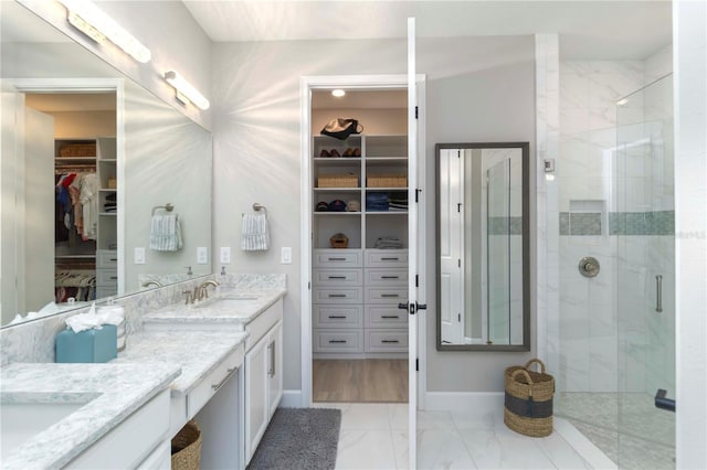 15752 Sacile Ln, Bradenton, FL 34211 - bathroom featuring double vanity, a spacious closet, marble look tile flooring, a shower stall, and baseboards