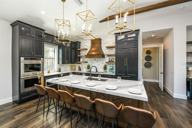 340 Jackson Dr, Sarasota, FL 34236 - kitchen with open shelves, custom range hood, stainless steel double oven, backsplash, and baseboards
