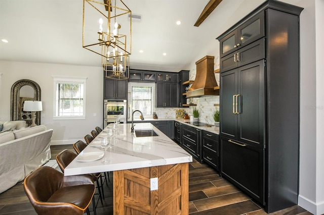 340 Jackson Dr, Sarasota, FL 34236 - kitchen featuring a sink, a chandelier, custom range hood, tasteful backsplash, and black electric stovetop