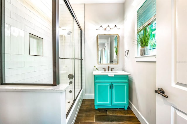 340 Jackson Dr, Sarasota, FL 34236 - full bath featuring shower / bath combination with glass door, vanity, wood finished floors, and baseboards