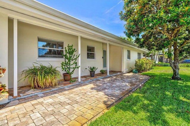 1324 Augusta Ln S, Saint Petersburg, FL 33707 - entrance to property with a yard, a patio, and stucco siding