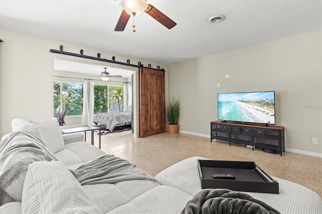 1324 Augusta Ln S, Saint Petersburg, FL 33707 - living room with speckle patterned floor, baseboards, a ceiling fan, and a barn door
