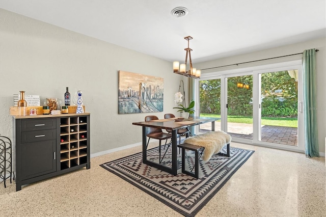 1324 Augusta Ln S, Saint Petersburg, FL 33707 - dining space featuring dark aggregate flooring, a chandelier, baseboards, and a textured wall