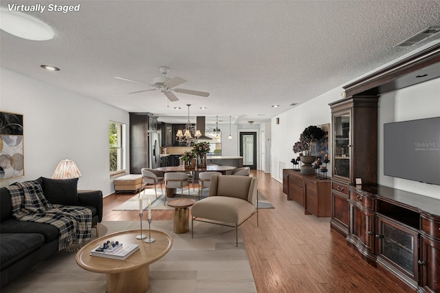 532 Oak Hill Cir Unit 12, Sarasota, FL 34232 - living room featuring ceiling fan, wood finished floors, a chandelier, a textured ceiling, and recessed lighting