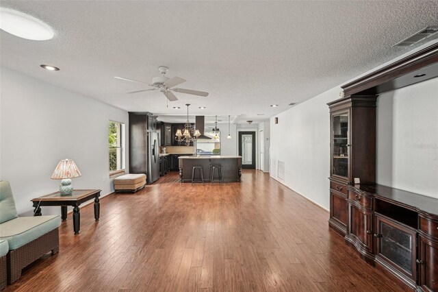 532 Oak Hill Cir Unit 12, Sarasota, FL 34232 - living area with a ceiling fan, a chandelier, dark wood finished floors, and a textured ceiling