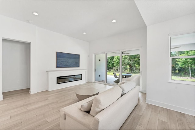 8069 Tidal Pointe Way, Sarasota, FL 34240 - living area featuring a glass covered fireplace, light wood-type flooring, baseboards, and recessed lighting