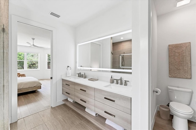 8069 Tidal Pointe Way, Sarasota, FL 34240 - ensuite bathroom featuring double vanity, toilet, a stall shower, baseboards, and a ceiling fan