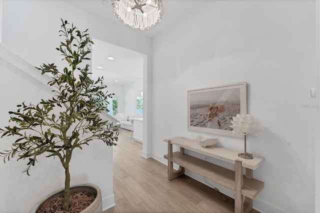 8069 Tidal Pointe Way, Sarasota, FL 34240 - hallway featuring light wood-style flooring, baseboards, a chandelier, and recessed lighting