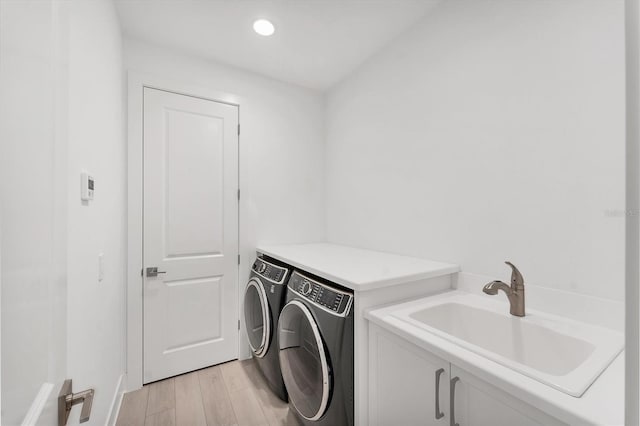8069 Tidal Pointe Way, Sarasota, FL 34240 - washroom with washing machine and dryer, cabinet space, light wood-style flooring, and baseboards