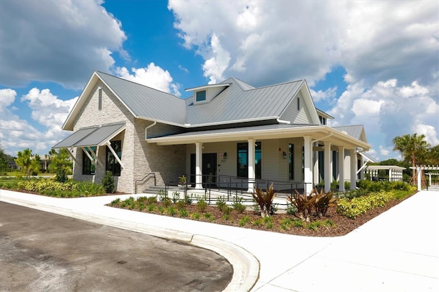 8069 Tidal Pointe Way, Sarasota, FL 34240 - view of front of house featuring covered porch, metal roof, and a standing seam roof