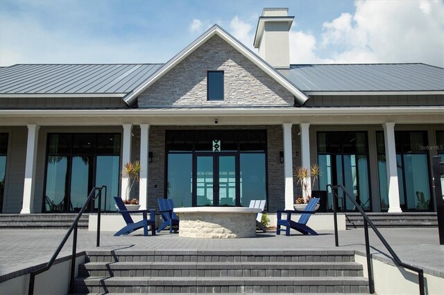 8069 Tidal Pointe Way, Sarasota, FL 34240 - rear view of property featuring a porch, a chimney, a standing seam roof, and metal roof