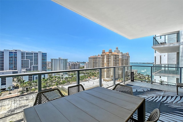 301 Quay Commons Unit 1208, Sarasota, FL 34236 - balcony with outdoor dining area, a city view, and a water view