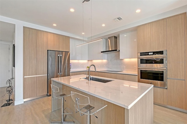301 Quay Commons Unit 1208, Sarasota, FL 34236 - kitchen featuring wall chimney exhaust hood, appliances with stainless steel finishes, a sink, modern cabinets, and recessed lighting