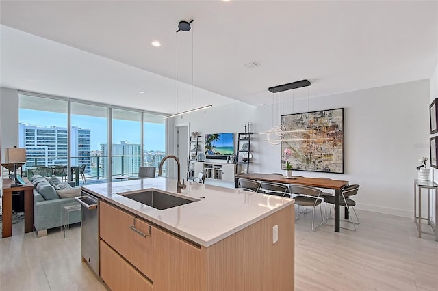 301 Quay Commons Unit 1208, Sarasota, FL 34236 - kitchen featuring a sink, modern cabinets, open floor plan, light brown cabinets, and an island with sink