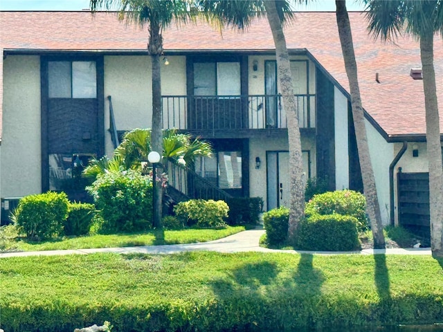 5400 34th St W Unit H12, Bradenton, FL 34210 - view of front facade featuring stucco siding, a front lawn, and a balcony