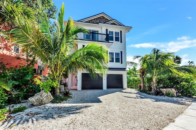 5219 Calle Menorca, Sarasota, FL 34242 - raised beach house with a balcony, a garage, and gravel driveway