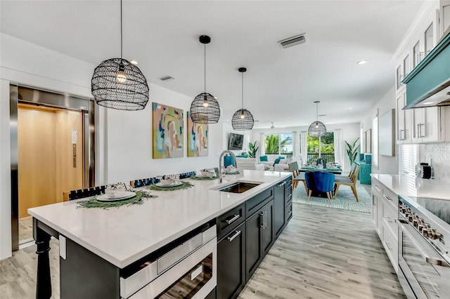 5219 Calle Menorca, Sarasota, FL 34242 - kitchen with appliances with stainless steel finishes, light countertops, an island with sink, white cabinets, and recessed lighting