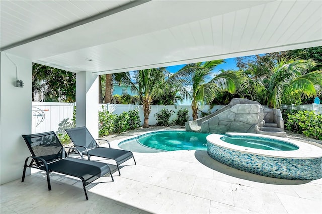 5219 Calle Menorca, Sarasota, FL 34242 - view of pool featuring a water slide, a fenced backyard, a patio area, and an in-ground hot tub