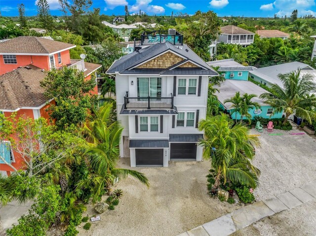 5219 Calle Menorca, Sarasota, FL 34242 - coastal home featuring a balcony, a garage, a residential view, and gravel driveway