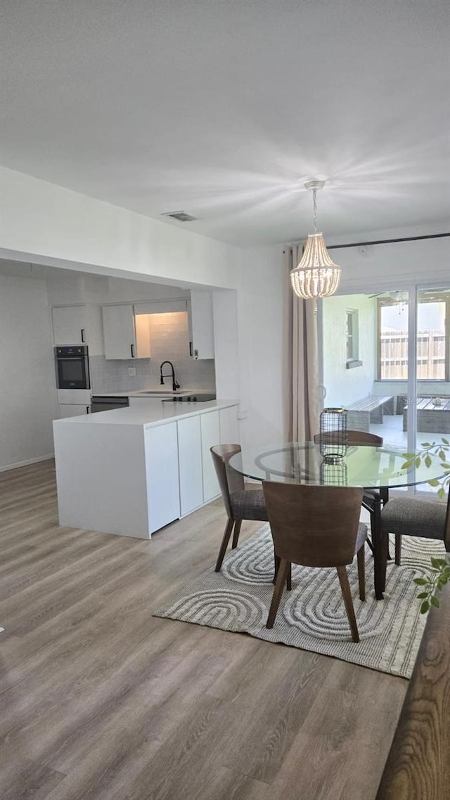 3730 Ferguson St, Sarasota, FL 34233 - dining room featuring light wood-style floors and a chandelier