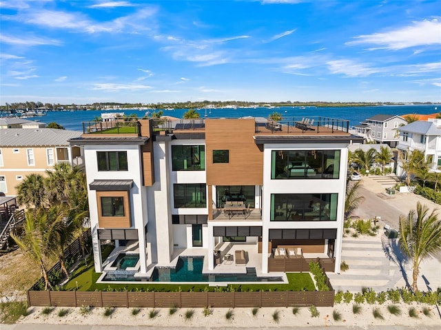 100 6th St S, Bradenton Beach, FL 34217 - rear view of house with a fenced backyard, a balcony, a water view, a patio, and an outdoor living space