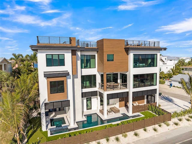100 6th St S, Bradenton Beach, FL 34217 - rear view of property with a balcony, outdoor lounge area, a fenced backyard, and stucco siding
