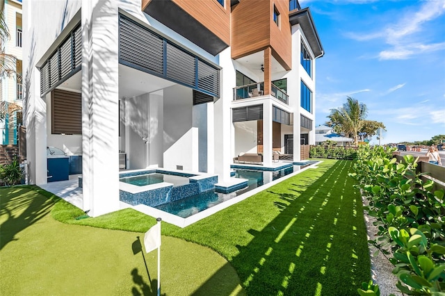 100 6th St S, Bradenton Beach, FL 34217 - rear view of house with a balcony, stucco siding, a ceiling fan, a yard, and a patio area