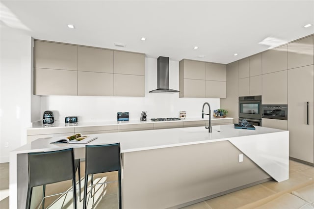 100 6th St S, Bradenton Beach, FL 34217 - kitchen featuring gray cabinetry, wall chimney exhaust hood, modern cabinets, an island with sink, and a sink