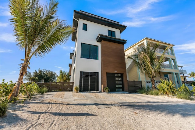100 6th St S, Bradenton Beach, FL 34217 - view of front of property featuring stucco siding, an attached garage, driveway, and a balcony