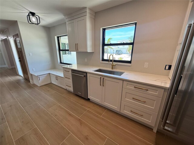 808 25th Ave W, Palmetto, FL 34221 - kitchen featuring a sink, dishwasher, healthy amount of natural light, and light wood-type flooring