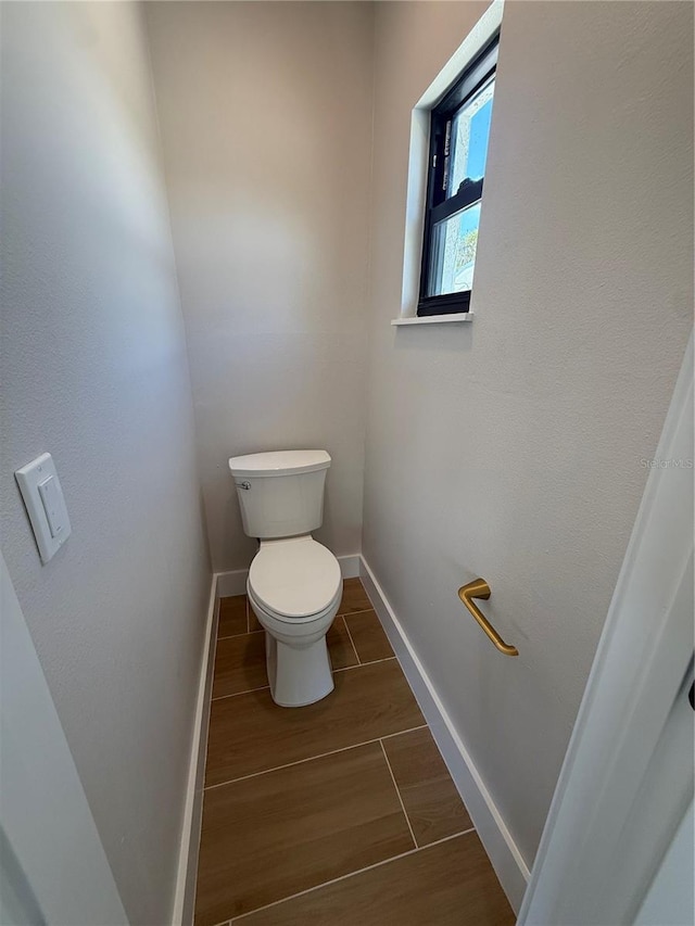 808 25th Ave W, Palmetto, FL 34221 - bathroom featuring toilet, baseboards, and wood finished floors