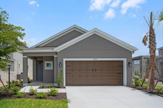 8632 Snowfall St, Sarasota, FL 34241 - ranch-style home with stucco siding, concrete driveway, and an attached garage