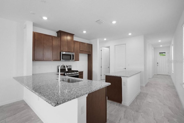 8632 Snowfall St, Sarasota, FL 34241 - kitchen featuring stainless steel appliances, a kitchen island, recessed lighting, light stone countertops, and a peninsula